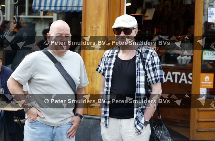 Amsterdam 17 augustus 2026
De stoet met Peter faber rijdt onder politiebegeleiding over de Haarlemmerstraat langs zijn favoriete cafe\'s . Vele mensen bewijzen hem een laatste eer. Arie Cupe met partner