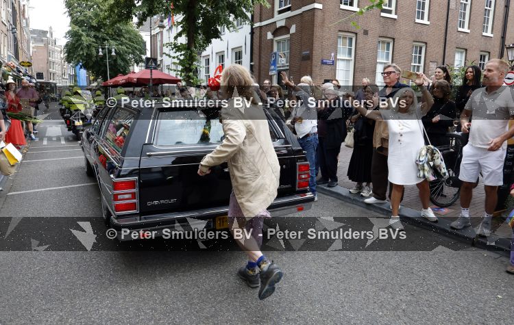 Amsterdam 17 augustus 2026
De stoet met Peter faber rijdt onder politiebegeleiding over de Haarlemmerstraat langs zijn favoriete cafe\'s . Vele mensen bewijzen hem een laatste eer.