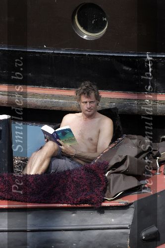 Amsterdam 3 april 2005
Jeroen Pauw leest boek  met ontbloot bovenlijf op zijn boot.