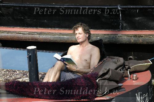 Amsterdam 3 april 2005
Jeroen Pauw leest boek  met ontbloot bovenlijf op zijn boot.