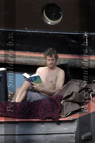Amsterdam 3 april 2005
Jeroen Pauw leest boek  met ontbloot bovenlijf op zijn boot.