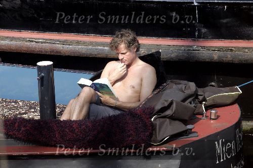 Amsterdam 3 april 2005
Jeroen Pauw leest boek  met ontbloot bovenlijf op zijn boot.