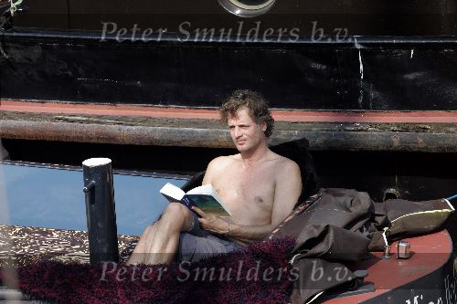 Amsterdam 3 april 2005
Jeroen Pauw leest boek  met ontbloot bovenlijf op zijn boot.
