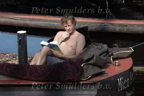 Amsterdam 3 april 2005
Jeroen Pauw leest boek  met ontbloot bovenlijf op zijn boot.