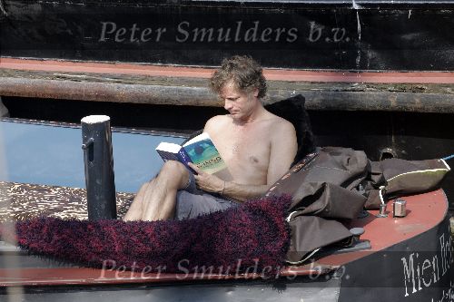 Amsterdam 3 april 2005
Jeroen Pauw leest boek met ontbloot bovenlijf op zijn boot.