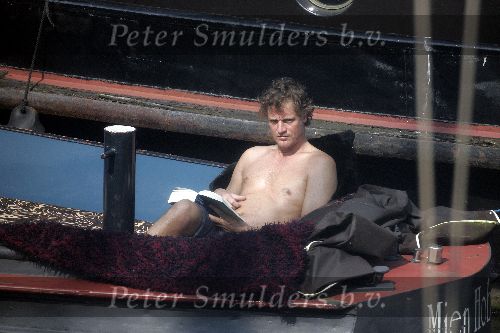 Amsterdam 3 april 2005
Jeroen Pauw leest boek  met ontbloot bovenlijf op zijn boot.