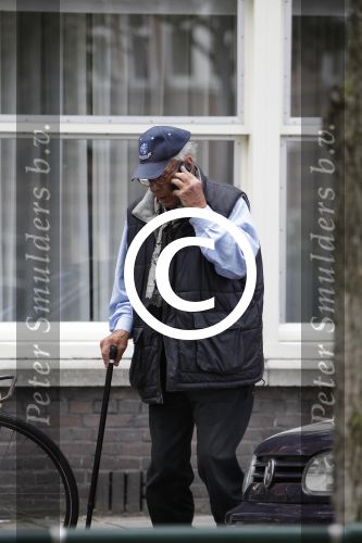 Amsterdam, 19 Juli 2011
Piet Romer msamen met zijn vrouw en hulp voor zijn huis
druk bellend.
Foto Peter Smulders BV