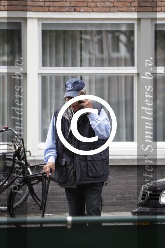 Amsterdam, 19 Juli 2011
Piet Romer msamen met zijn vrouw en hulp voor zijn huis
druk bellend.
Foto Peter Smulders BV