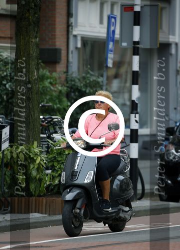 Amsterdam 10 augustus 2015
Caroline Tensen op haar Vespa scooter rijdend door Amsterdam