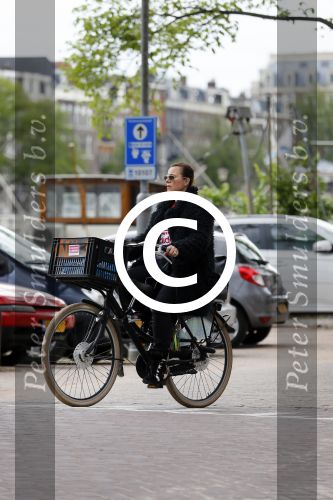 Amsterdam 20 juni 2015  
Trijntje Oosterhuis met zoontje op de fiets in Amsterdam. Trijntje gaat een huis binnen en ze geeft een toerist uitleg over hoe waar naartoe te lopen.