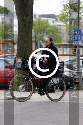 Amsterdam 20 juni 2015  
Trijntje Oosterhuis met zoontje op de fiets in Amsterdam. Trijntje gaat een huis binnen en ze geeft een toerist uitleg over hoe waar naartoe te lopen.