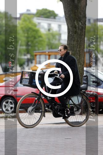 Amsterdam 20 juni 2015  
Trijntje Oosterhuis met zoontje op de fiets in Amsterdam. Trijntje gaat een huis binnen en ze geeft een toerist uitleg over hoe waar naartoe te lopen.