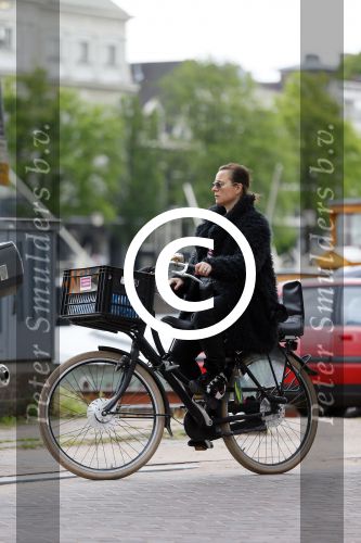 Amsterdam 20 juni 2015  
Trijntje Oosterhuis met zoontje op de fiets in Amsterdam. Trijntje gaat een huis binnen en ze geeft een toerist uitleg over hoe waar naartoe te lopen.