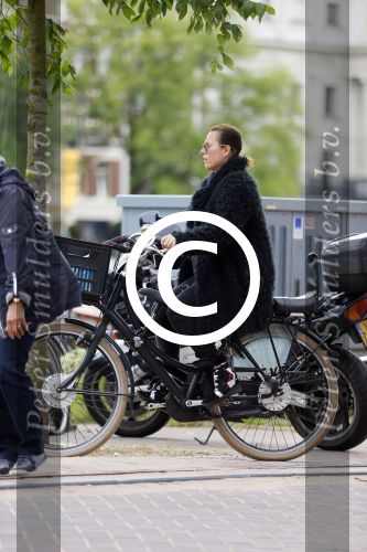 Amsterdam 20 juni 2015  
Trijntje Oosterhuis met zoontje op de fiets in Amsterdam. Trijntje gaat een huis binnen en ze geeft een toerist uitleg over hoe waar naartoe te lopen.