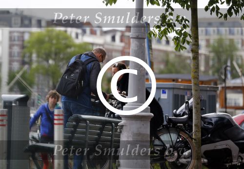 Amsterdam 20 juni 2015  
Trijntje Oosterhuis met zoontje op de fiets in Amsterdam. Trijntje gaat een huis binnen en ze geeft een toerist uitleg over hoe waar naartoe te lopen.