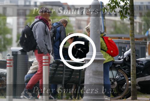 Amsterdam 20 juni 2015  
Trijntje Oosterhuis met zoontje op de fiets in Amsterdam. Trijntje gaat een huis binnen en ze geeft een toerist uitleg over hoe waar naartoe te lopen.