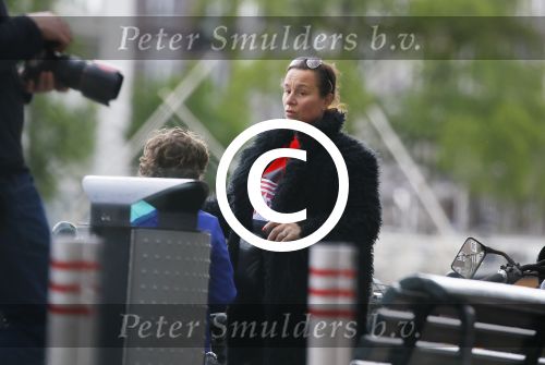 Amsterdam 20 juni 2015  
Trijntje Oosterhuis met zoontje op de fiets in Amsterdam. Trijntje gaat een huis binnen en ze geeft een toerist uitleg over hoe waar naartoe te lopen.