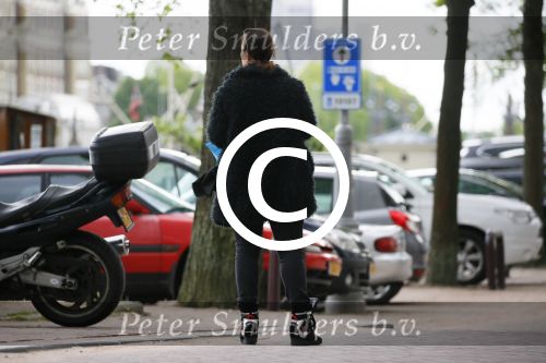 Amsterdam 20 juni 2015  
Trijntje Oosterhuis met zoontje op de fiets in Amsterdam. Trijntje gaat een huis binnen en ze geeft een toerist uitleg over hoe waar naartoe te lopen.