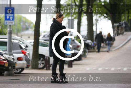 Amsterdam 20 juni 2015  
Trijntje Oosterhuis met zoontje op de fiets in Amsterdam. Trijntje gaat een huis binnen en ze geeft een toerist uitleg over hoe waar naartoe te lopen.