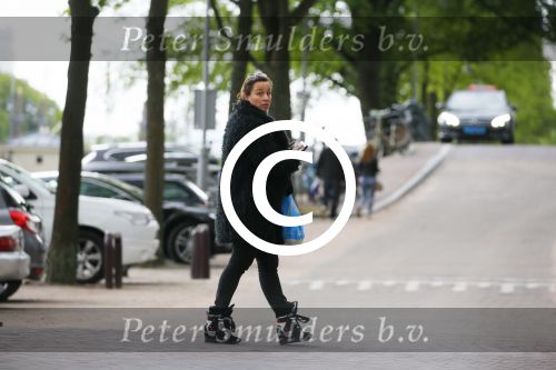 Amsterdam 20 juni 2015  
Trijntje Oosterhuis met zoontje op de fiets in Amsterdam. Trijntje gaat een huis binnen en ze geeft een toerist uitleg over hoe waar naartoe te lopen.
