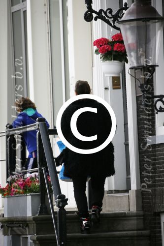 Amsterdam 20 juni 2015  
Trijntje Oosterhuis met zoontje op de fiets in Amsterdam. Trijntje gaat een huis binnen en ze geeft een toerist uitleg over hoe waar naartoe te lopen.