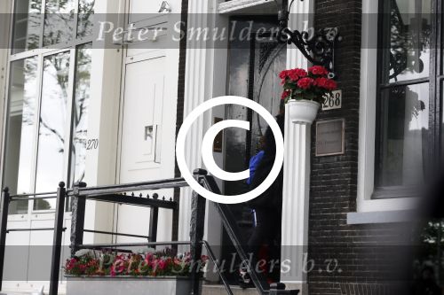 Amsterdam 20 juni 2015  
Trijntje Oosterhuis met zoontje op de fiets in Amsterdam. Trijntje gaat een huis binnen en ze geeft een toerist uitleg over hoe waar naartoe te lopen.