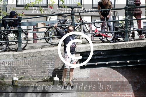 Amsterdam 13 juli 2016  
Selwyn Senatori zit samen met zijn vriendin op bankje zijn boek te signeren als haar fiets omvalt en haarvtas met mobieltje etc het water in valt . Een rondvaartboot vist alles eruit