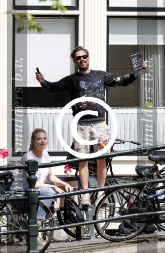 Amsterdam 13 juli 2016  
Selwyn Senatori zit samen met zijn vriendin op bankje zijn boek te signeren als haar fiets omvalt en haarvtas met mobieltje etc het water in valt . Een rondvaartboot vist alles eruit