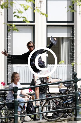 Amsterdam 13 juli 2016  
Selwyn Senatori zit samen met zijn vriendin op bankje zijn boek te signeren als haar fiets omvalt en haarvtas met mobieltje etc het water in valt . Een rondvaartboot vist alles eruit