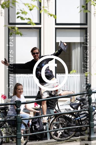 Amsterdam 13 juli 2016  
Selwyn Senatori zit samen met zijn vriendin op bankje zijn boek te signeren als haar fiets omvalt en haarvtas met mobieltje etc het water in valt . Een rondvaartboot vist alles eruit