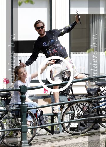 Amsterdam 13 juli 2016  
Selwyn Senatori zit samen met zijn vriendin op bankje zijn boek te signeren als haar fiets omvalt en haarvtas met mobieltje etc het water in valt . Een rondvaartboot vist alles eruit