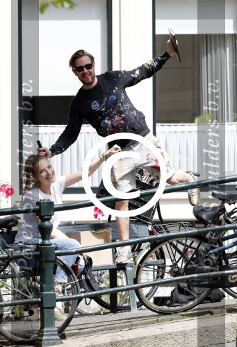 Amsterdam 13 juli 2016  
Selwyn Senatori zit samen met zijn vriendin op bankje zijn boek te signeren als haar fiets omvalt en haarvtas met mobieltje etc het water in valt . Een rondvaartboot vist alles eruit