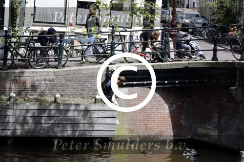 Amsterdam 13 juli 2016  
Selwyn Senatori zit samen met zijn vriendin op bankje zijn boek te signeren als haar fiets omvalt en haarvtas met mobieltje etc het water in valt . Een rondvaartboot vist alles eruit