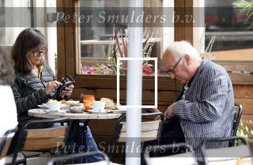 Amsterdam 1 juli 2024
Youp van t Hek en zijn vrouw Debby Petter op terras en op de fiets in Amsterdam zuid. Ze zijn beide druk op hun telefoon.