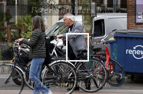 Amsterdam 1 juli 2024
Youp van t Hek en zijn vrouw Debby Petter op terras en op de fiets in Amsterdam zuid. Ze zijn beide druk op hun telefoon.