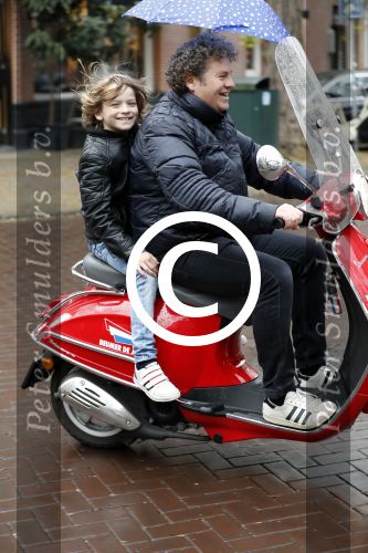 Amsterdam 23 november 201t6
Dirk Zeelenberg met zijn zoon onder paraplu op vespa scooter.