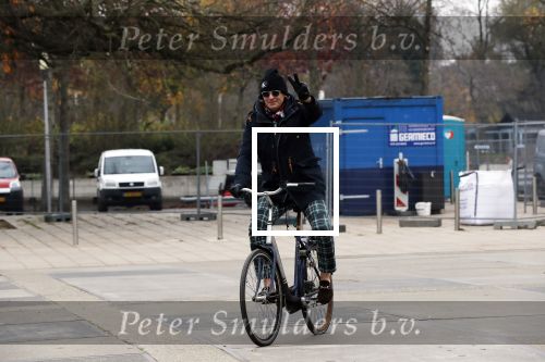 Amsterdam 22 novcember 2018
Matthijs v Nieuwkerk met muts op en geruiten broek op de fiets.