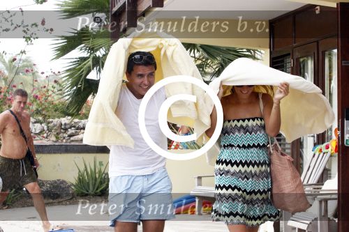 Curacao 30 december 2011
Jan en Lisa Smit schuilen onder handdoek voor regen bui op curacao .
Peter Smulders bv