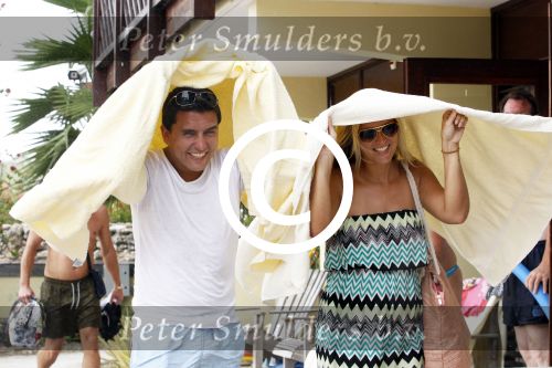 Curacao 30 december 2011
Jan en Lisa Smit schuilen onder handdoek voor regen bui op curacao .
Peter Smulders bv