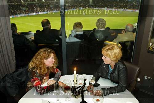 Eindhoven 31 Januari 2003
Restaurant Avangarde sinds januari 2003 een Michelin ster met op de achtergrond het PSV stadion.
Niet iedereen heeft oog voor het voetballen zoals te zien is aan beide dames die praten over het leven terwijl op de achtergrond de wedstrijd wordt gespeeld tussen PSV en vitesse.