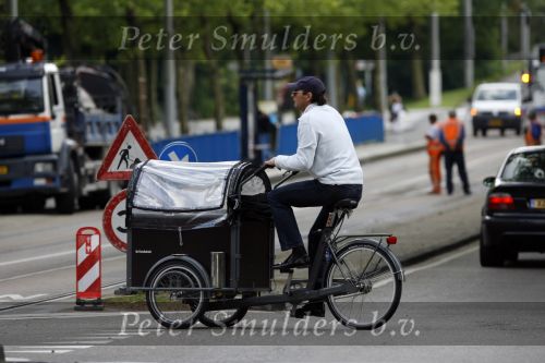 Amsterdam 10 juli 2007
Edwin de Roy v Zuidewijn met hond in bakfiets verbergt zich achter pet.
Peter Smulders bv