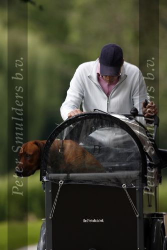 Amsterdam 10 juli 2007
Edwin de Roy v Zuydewijn met hond in bakfiets verbergt zich achter pet.