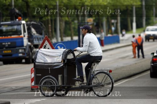 Amsterdam 10 juli 2007
Edwin de Roy v Zuydewijn met hond in bakfiets verbergt zich achter pet.