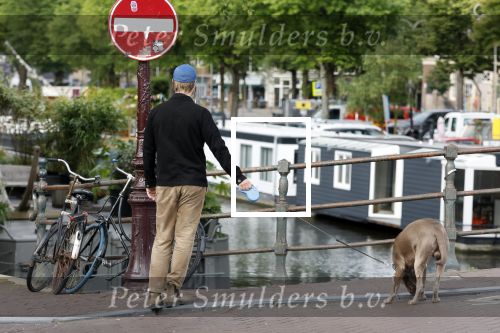Amsterdam 5 juni 2025
Thijs Romer met petje op laat zijn hond uit in het centrum van Amsterdam.