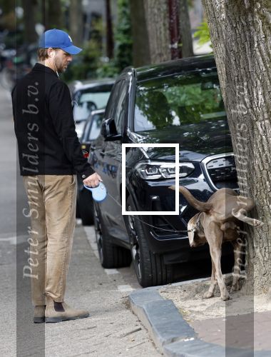 Amsterdam 5 juni 2025
Thijs Romer met petje op laat zijn hond uit in het centrum van Amsterdam.