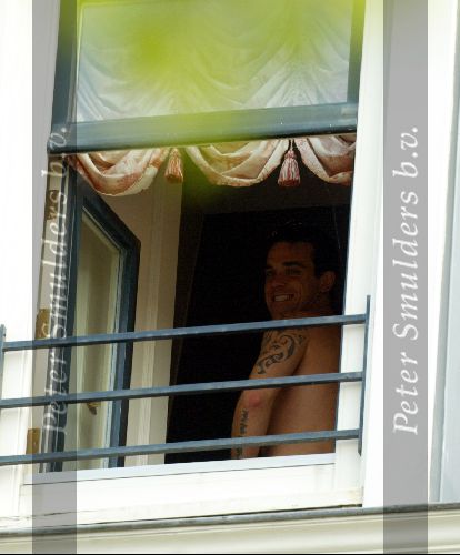Amsterdam 15 juli 2003
Robbie Williams met tatoeage varend in de grachten van Amsterdam hier op zijn hotelkamer bij het Amstel Hotel