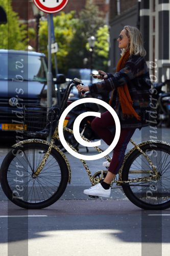 Amsterdam 21 mei 2015  
Carolien Spoor met mobiel bellend op de fiets.