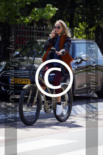 Amsterdam 21 mei 2015  
Carolien Spoor met mobiel bellend op de fiets.