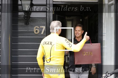 Purmerend 16 mei 2020
Dries Roelvink brengt op de fiets in een gele wielrentrui/broek een pakketje van OGER naar Danny de Munk die thuyis de deur opent als dries aan belt .