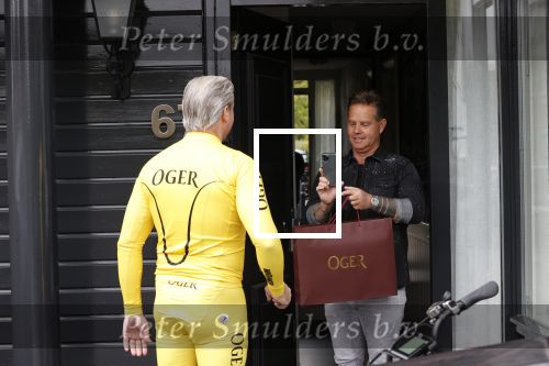 Purmerend 16 mei 2020
Dries Roelvink brengt op de fiets in een gele wielrentrui/broek een pakketje van OGER naar Danny de Munk die thuyis de deur opent als dries aan belt .